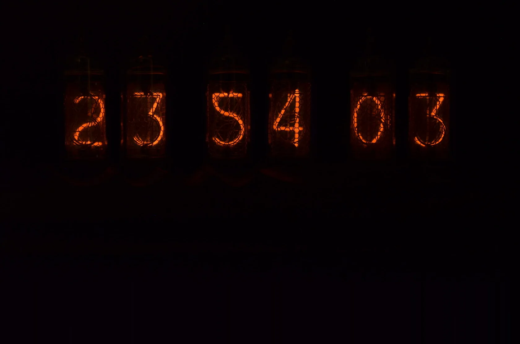 Оранжевые цифры 23:54:03 в полной темноте